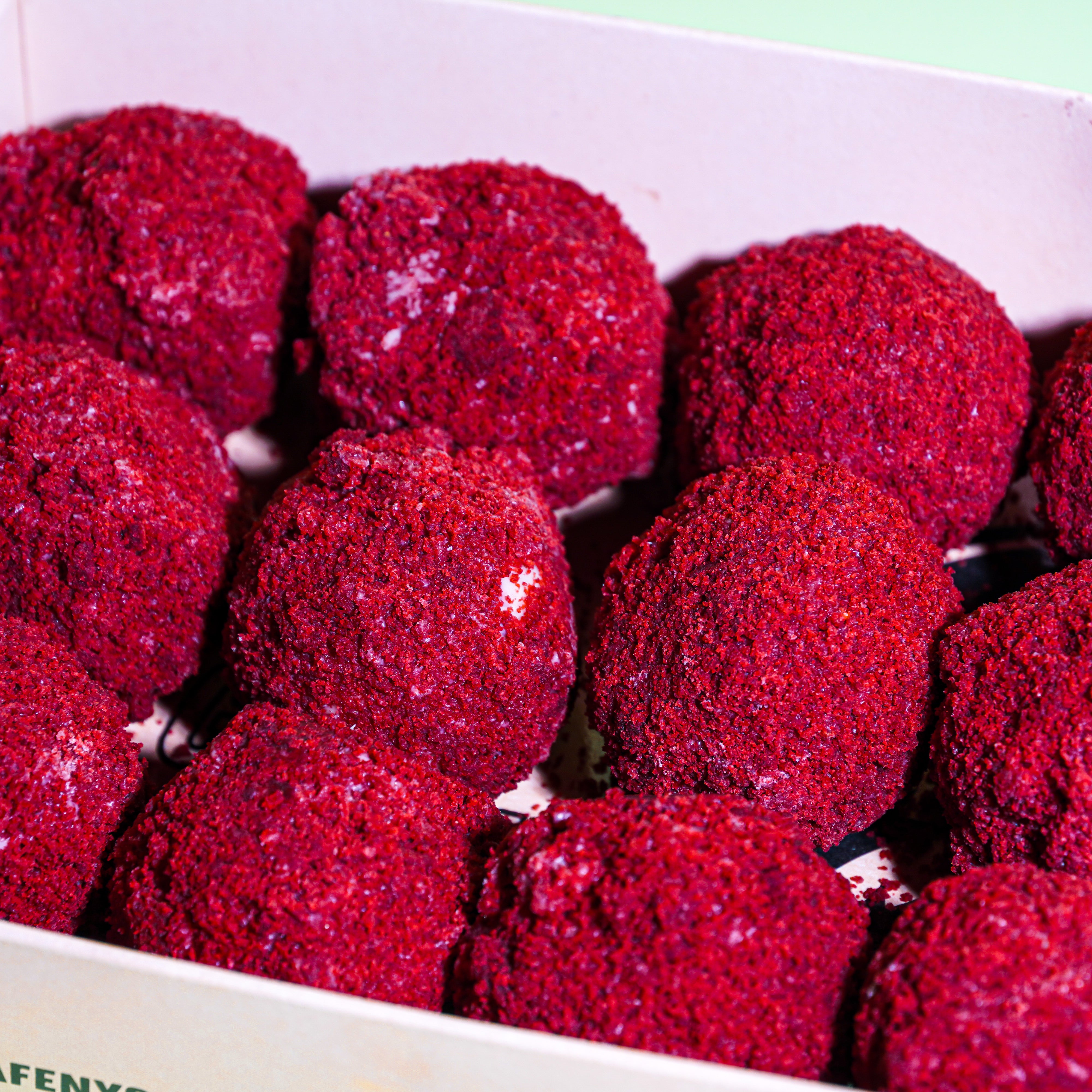 An enticing close-up image showcasing Red Velvet Truffles. The velvety texture of each truffle is beautifully captured, highlighting the rich red hue and delicate chocolate coating. This closeup provides a tempting glimpse into the decadent allure of these Red Velvet Truffles, inviting indulgence and delight for chocolate connoisseurs.